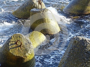 Marine concrete breakwaters anchors in shallow water. Traveling-wave protection
