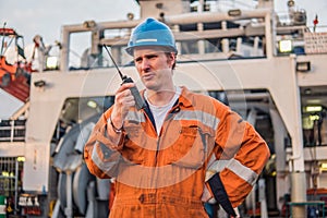 Marine Deck Officer or Chief mate on deck of ship with VHF radio