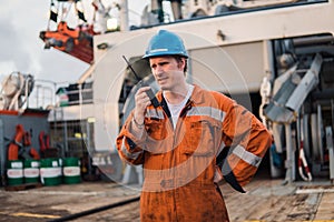 Marine Deck Officer or Chief mate on deck of ship with VHF radio