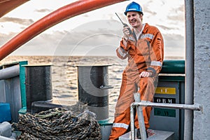 Marine Deck Officer or Chief mate on deck of ship with VHF radio photo