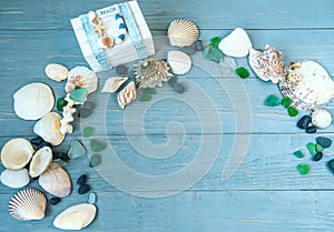 Marine decorative background made of shells and marine-themed details on a light blue wooden background.