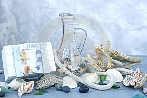 Marine decorative background made of shells and marine-themed details on a light blue wooden background.