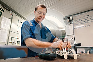 Marine electrical engineer officer in engine control room ECR. He works in workshop