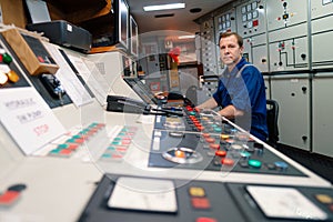 Marine engineer officer controlling vessel engines and propulsion in engine control room