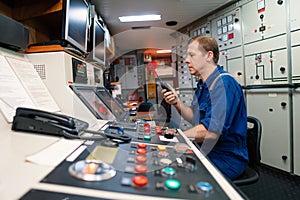 Marine engineer officer controlling vessel engines and propulsion in engine control room