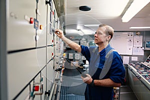 Marine engineer officer controlling vessel engines and propulsion in engine control room