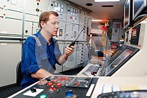 Marine engineer officer controlling vessel engines and propulsion in engine control room