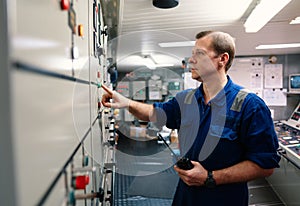 Marine engineer officer controlling vessel engines and propulsion in engine control room