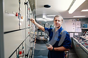 Marine engineer officer controlling vessel engines and propulsion in engine control room