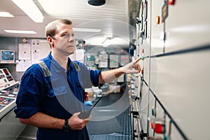 Marine engineer officer controlling vessel engines and propulsion in engine control room