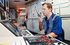 Marine engineer officer controlling vessel engines and propulsion in engine control room photo