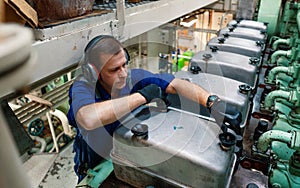 Marine engineer officer controlling vessel enginesand propulsion in engine control room ECR