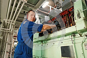 Marine engineer officer controlling vessel enginesand propulsion in engine control room ECR