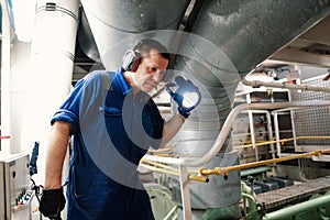 Marine engineer officer controlling vessel enginesand propulsion in engine control room ECR