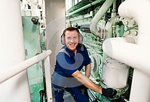 Marine engineer officer controlling vessel enginesand propulsion in engine control room ECR