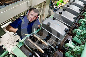 Marine engineer officer controlling vessel enginesand propulsion in engine control room ECR