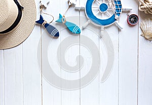Marine items on wooden background. Sea objects: straw hat, swimsuit, fish, shells . flat lay, copy space