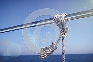 Marine Knot Detail Stainless Steel Boat Railing. Marine Fender Knot Around Boat Lee. Close-up nautical knot rope on sail boat