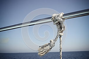 Marine Knot Detail Stainless Steel Boat Railing. Marine Fender Knot Around Boat Lee. Close-up nautical knot rope on sail boat