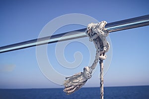 Marine Knot Detail Stainless Steel Boat Railing. Marine Fender Knot Around Boat Lee. Close-up nautical knot rope on sail boat