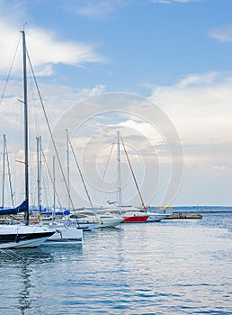 Marine landscape with a lot of luxury boats and yachts at sunset moored at pier. Summer holidays under the sails yacht as your