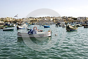 Marine with multi-colored painted boats against background of low lodges