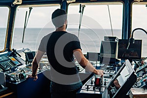 Marine navigational officer is maneuvering ship or vessel photo