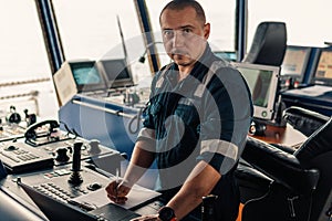 Marine navigational officer is using laptop or notebook at sea