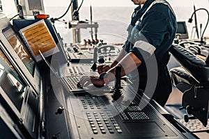 Marine navigational officer is using laptop or notebook at sea