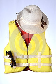 Marine safety equipment, flotation device and water activities concept with a yellow chapel life jacket and summer glasses