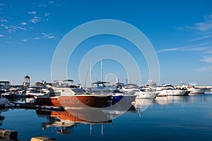 Marine Station with yachts on the shore of the blue Black Sea in Sochi on a sunny day under the blue sky, white yachts.