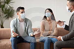 Couple talking at therapy session with male therapist