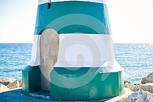 Maritime lighthouse door with sunshining waters on the outside background