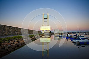 Maritime watchtower of A Coruna reflected in the water at sunset