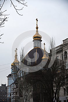 Mariupol Cathedral on gloomy day, brown dome with golden cross towers