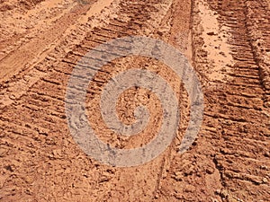 The mark of heavy vehicle tires that have gone through a muddy soil.