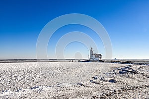 The lighthouse of Marken, `het Paard van Marken` in winter and the frozen Markermeer, Holland