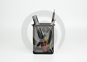 Markers, pen, pencil in black basket on white backgroun