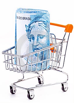 market cart with isolated white background, shopping basket, with large banknote of 100 reais from brazil inside photo