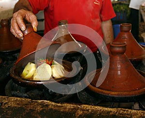 Market cook holding a cover of a tajine, Morocco