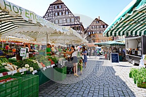 Weekly farmers market in front of ancient historic houses, half timbered houses of Swabian Hall, Baden-Wuerttemberg, Germany. photo