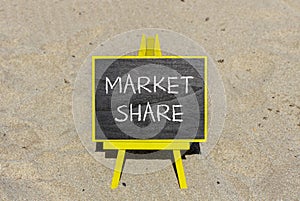 Market share symbol. Concept words Market share on beautiful black chalk blackboard on a beautiful sand beach background. Business