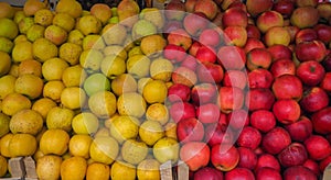 A pile of yellow and red apples on a market stall