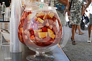 Market stand with punch drinks. Row of serving bowls full of punch with various types of fruits. photo