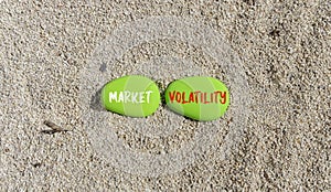 Market volatility symbol. Concept words Market volatility on beautiful green stone. Beautiful sand beach background. Business