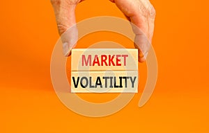 Market volatility symbol. Concept words Market volatility on beautiful wooden blocks. Beautiful orange table orange background.