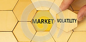 Market volatility symbol. Concept words Market volatility on beautiful wooden puzzles. Beautiful yellow paper background.