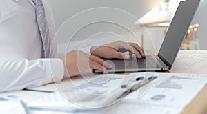 Marketers use computers to analyze documents and graphs of financial information about real estate investment budgets photo