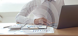 Marketers use computers to analyze documents and graphs of financial information about real estate investment budgets photo