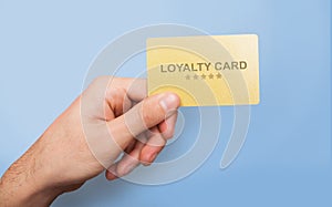 Marketing and client relations. Young guy showing loyalty card on blue background, close up of hand. Collage